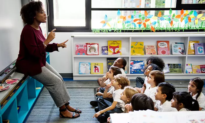 An elementary teacher leads her young students through an activity