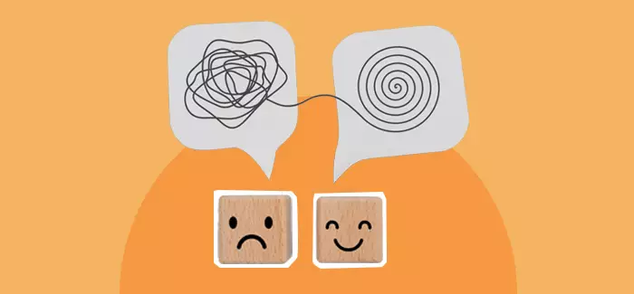 Two blocks, one with a sad face, another with a happy face, to signify stress reduction