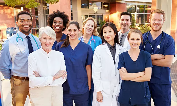 一群护士站在一起，在医院外微笑