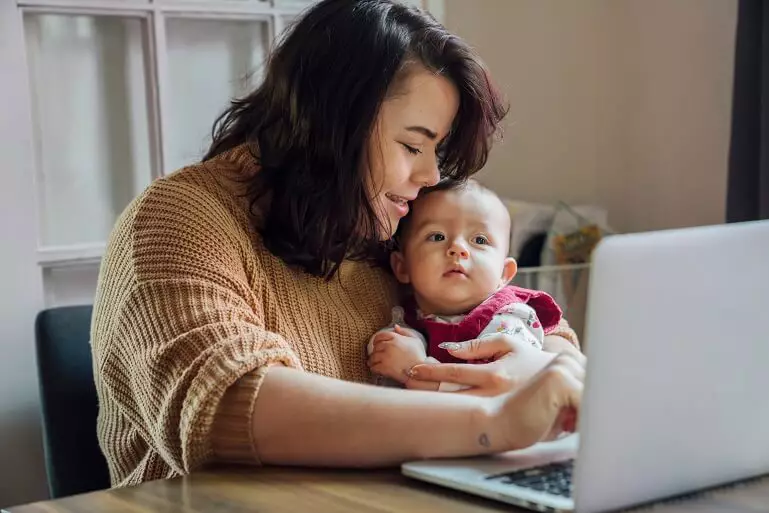 mom with baby doing homework online