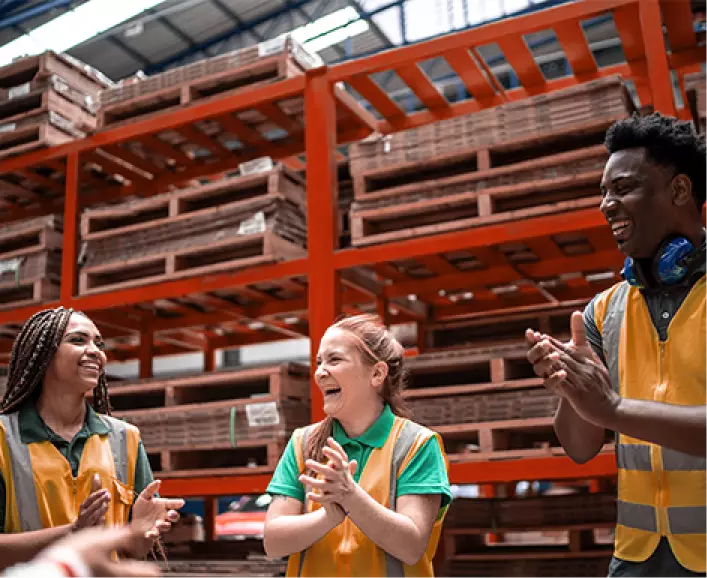 Workers in a warehouse clap in unison to get energized for the work day