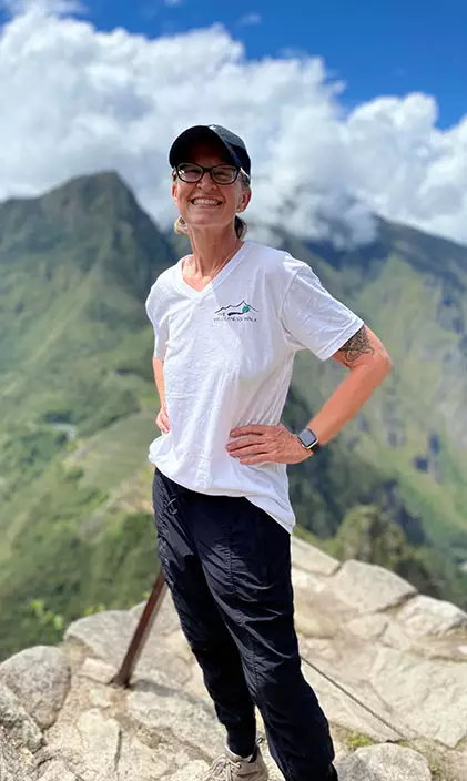 Christine Hunter smiling on top of a mountain