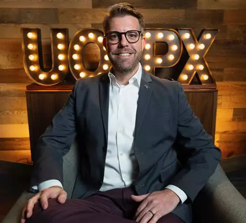 Degrees of Success host Keith Chandler smiling while sitting in the studio.