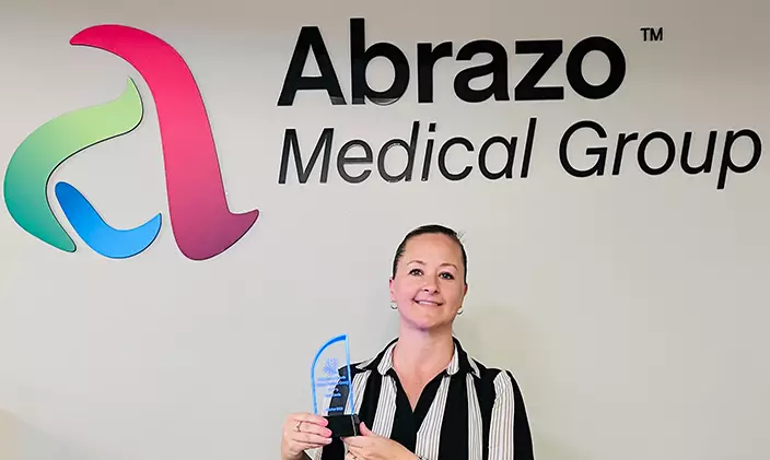 Terri Cascia holds an award at work