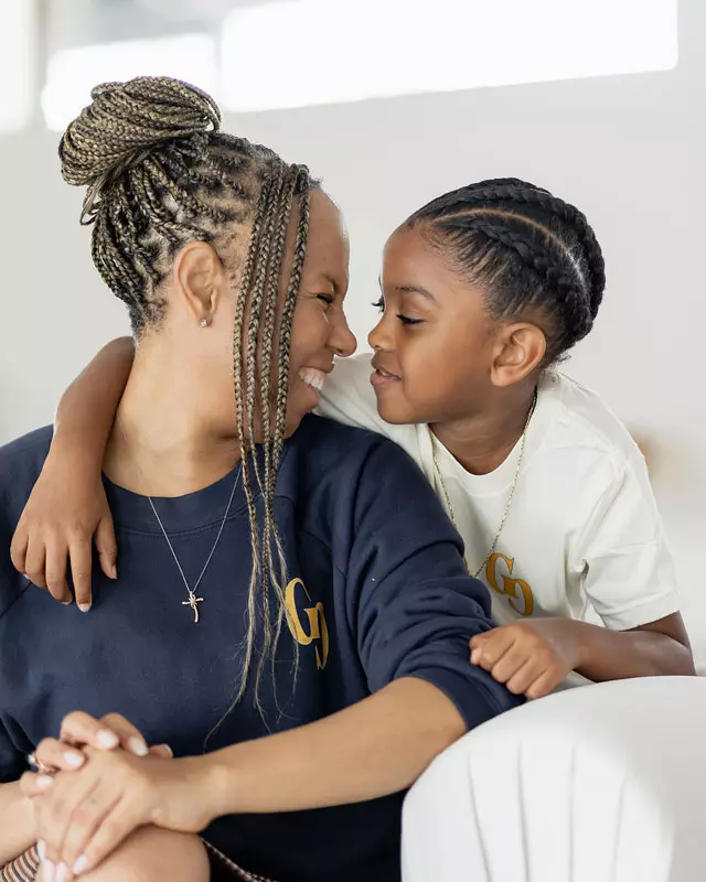 Freda Richards smiling and touching noses with her young son in a candid, loving moment.