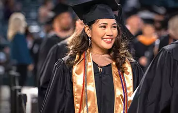 A happy accounting bachelor's degree graduate walks at the commencement ceremony