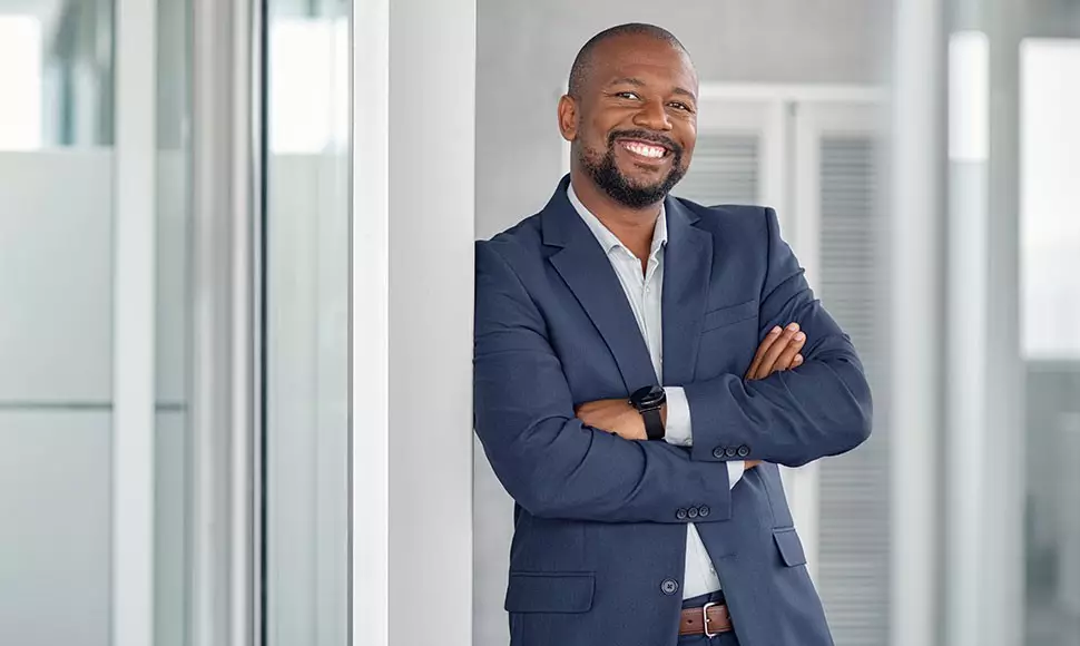 a veteran-owned businessman smiling with his arms crossed
