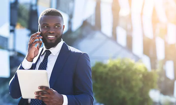 African american city manager talking on cellphone and holding tablet