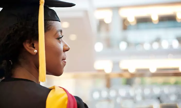 An education graduate gazes out at the commencement crowd