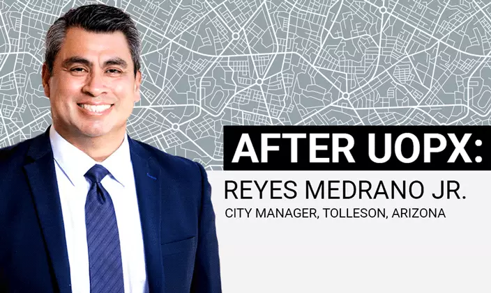 Reyes Medrano Jr stands smiling in front of a grid map