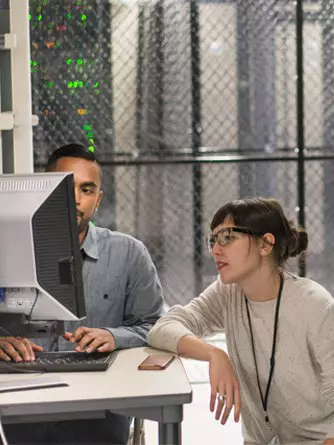 Two technology professionals collaborating in a server room