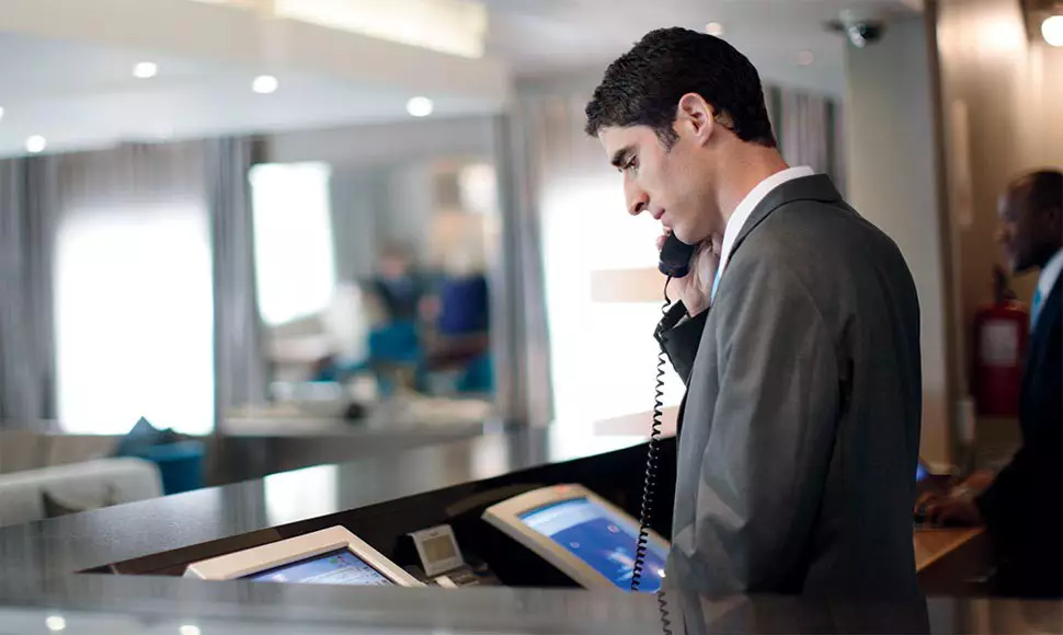 Hotel worker on phone at front desk