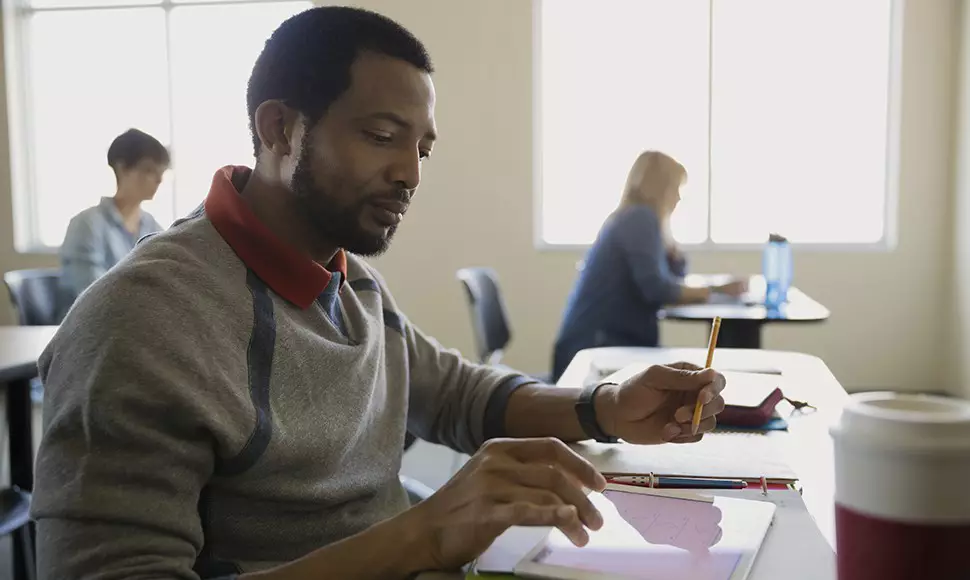 A young adult student sits in class