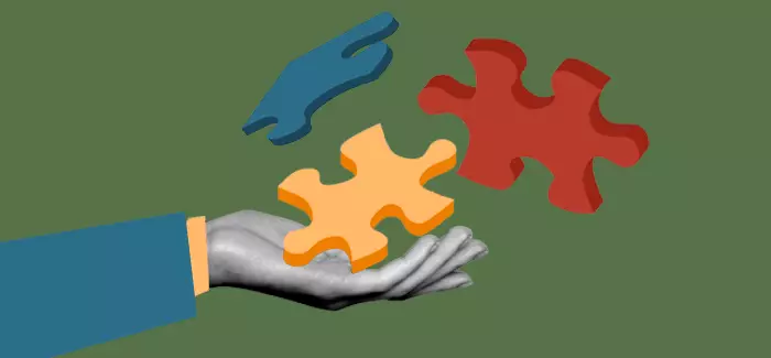 Hand presenting puzzle pieces to reflect fragmented skills in the workforce
