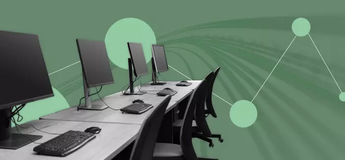 A row of desktop computers and empty chairs to signify network mapping