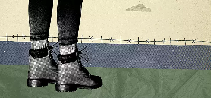 A juvenile's legs shown from the knees down, standing in front of a barbed wire fence signifying how to become a juvenile corrections officer