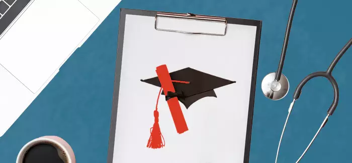 a cap and diploma on a clipboard next to a stethoscope to signify master of health administration