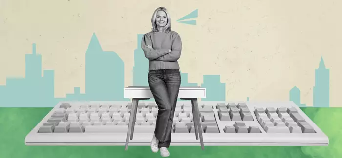 A woman sitting on a bench in front of a keyboard with a cityscape in the background to signify careers in cybersecurity