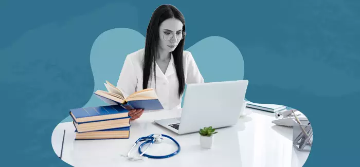 A female hospital administrator working at her desk on a laptop computer.