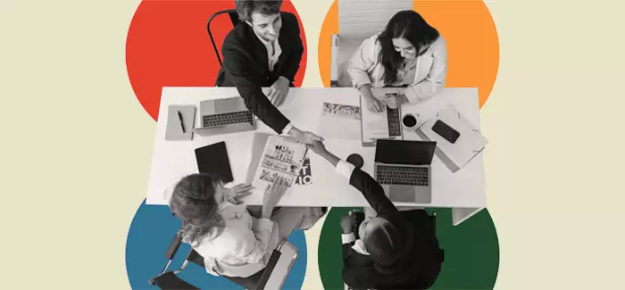 Four students sitting at a table networking at a professional business organization meeting 
