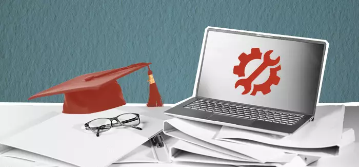 a laptop on papers next to glasses and a graduation cap to signify essential tools and classes for MBA students