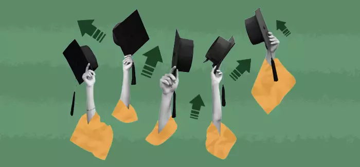 A group of arms in graduation gowns waving graduation caps adter they've gotten master's degrees from University of Phoenix