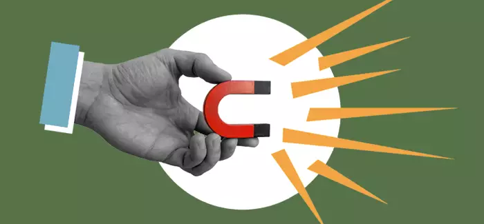 A hand holding a magnet to signify targeted marketing