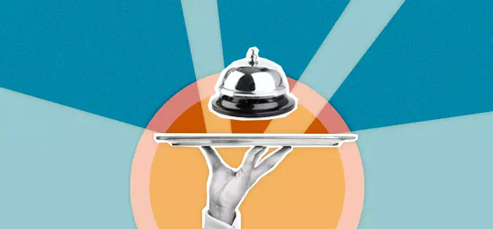 Hand holding serving tray with service bell to signify hospitality management