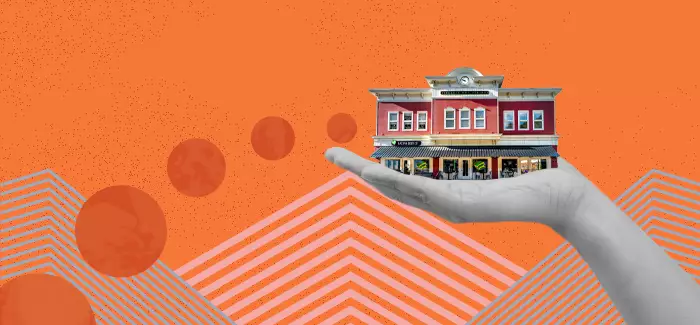 Hand holding a building to signify tips for successfully starting a business