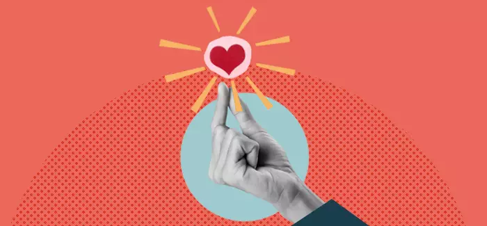 A hand holding a paper heart to represent jobs that require a degree in social work