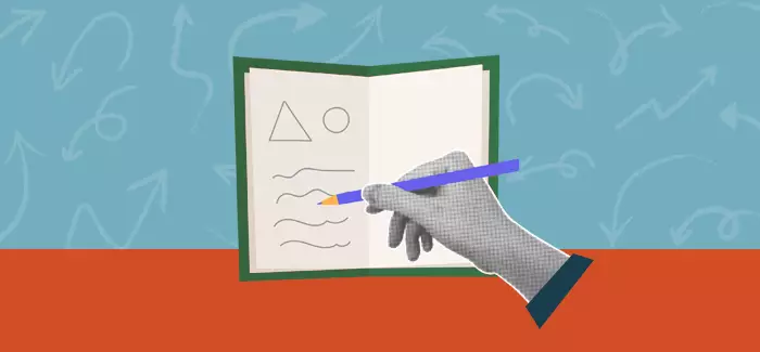 The hand of an instructional designer in education writing in a notebook