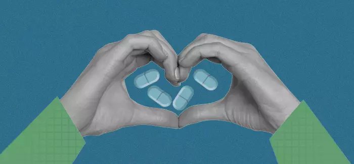 Two hands making a heart shape with pills in the middle of the heart to represent the care that is given in community health centers