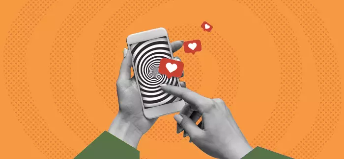 A hand tapping hearts on a phone screen to represent media psychology