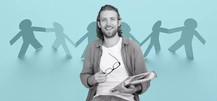 Man with a 3-ring binder holding his eyeglasses in front of a blue background with cut-out figures of people to signify how to become a social worker
