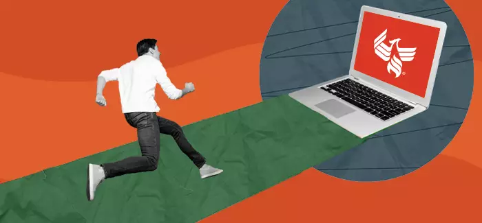 Man runs down a path toward a laptop in a mad dash to earn his bachelor’s degree completely online
