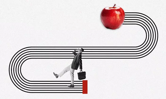 Adult student walking along a path leading to an apple representin education