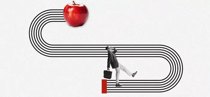 Adult student walking along a path leading to an apple representin education