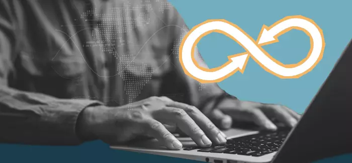 Hands typing on a laptop to represent what is devops
