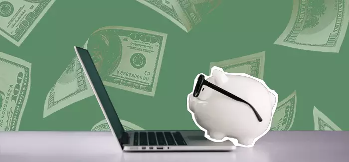 A piggy bank with sunglasses on, overlooking a laptop with hundred dollar bills falling in the background, to signify financial analyst