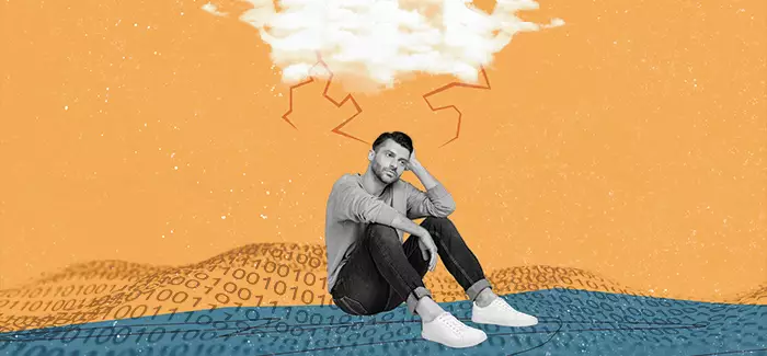 Tired man suffering from IT burnout sitting along on a blanket made of code, with a cloud and lightening in the background