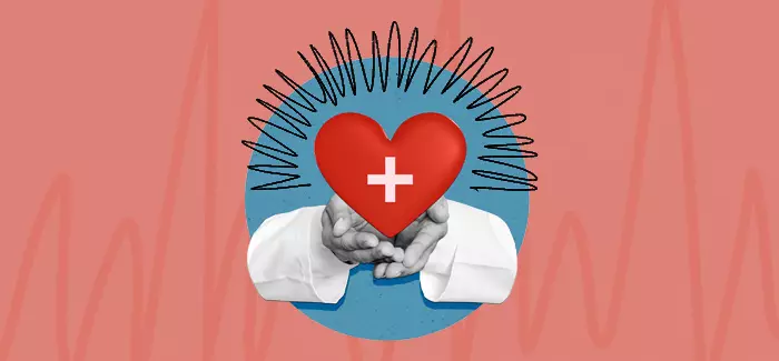 Hands holding a red heart with a medical white cross in the middle to signify health education specialist