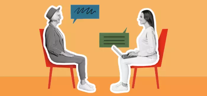 Two women sitting across from each other, once asking the other interview questions