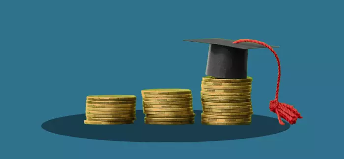 Stacks of coins, one of which is topped with a graduation cap to signify direct billing for tuition assistance