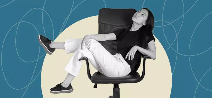 Female manager who uses the laissez-faire leadership style leaning back on an office chair