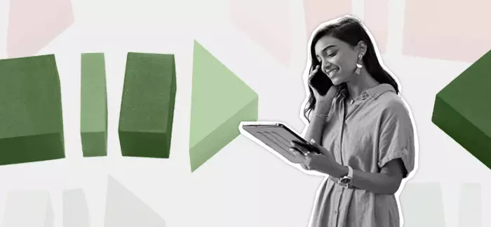 A woman on the phone while looking over work documents to represent a solopreneur