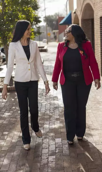 Felicia and a colleague walk towards her storefront