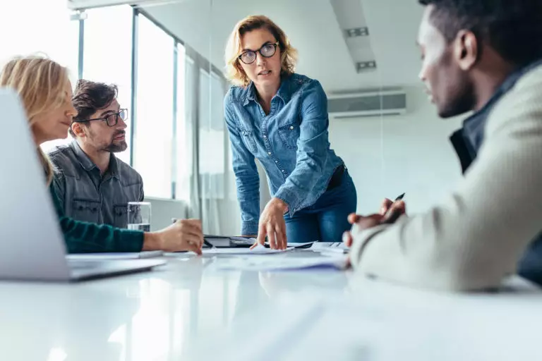 Business woman demonstrating soft skills by leading a presentation during a work meeting