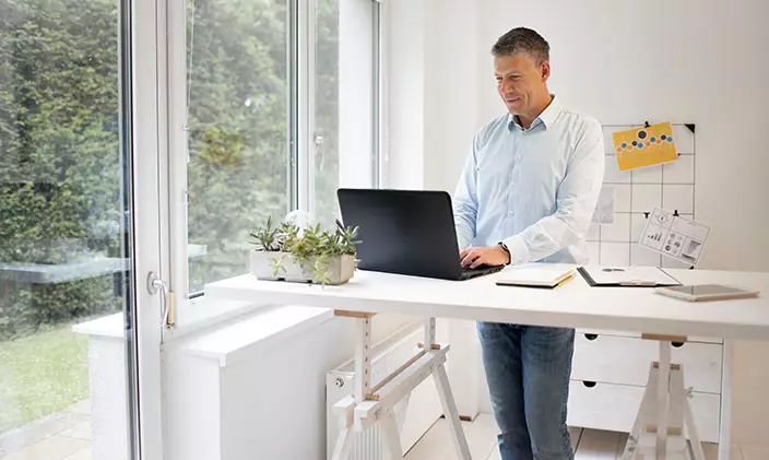 Businessman standing and working on a laptop