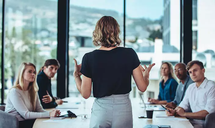Female manager leading meeting to signify autocratic leadership