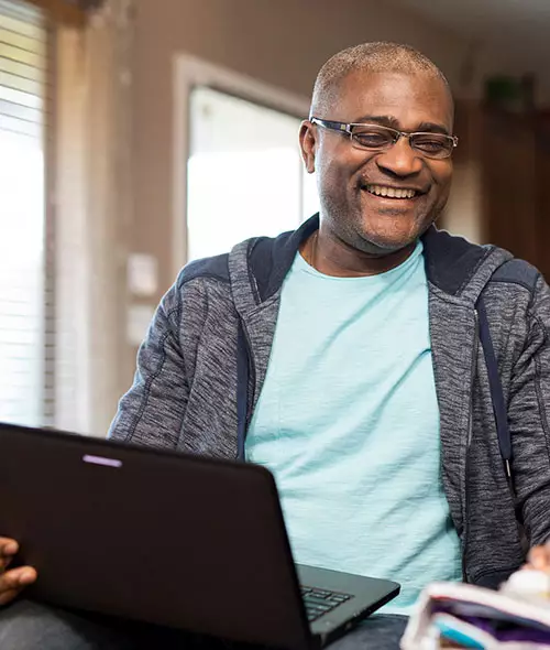 A case manager, seen laughing with a client, can advance their career through advanced education